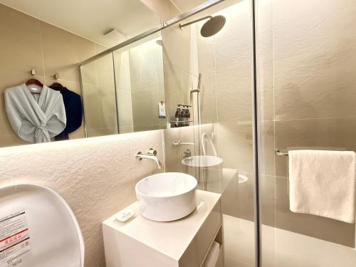 제주 신성의 숲 웰니스 호텔 في Haean: حمام مزود بمرحاض ومغسلة ومرآة