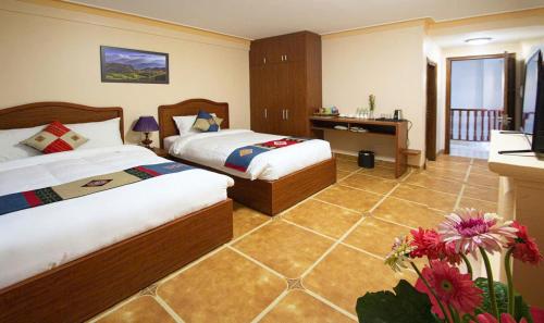 Sapa Symphony Hotel في سابا: غرفة فندق بها سريران ومكتب