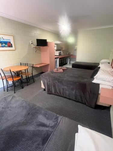a hotel room with a bed and a table and chairs at Yungaburra Park Motel in Yungaburra