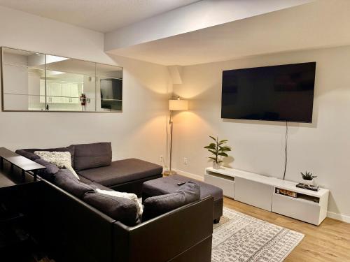a living room with a couch and a flat screen tv at The Seton Nook - 1BR Suite Near Seton Health Campus, Cineplex and YMCA in Calgary
