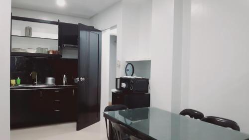 a kitchen with a table and a kitchen with a microwave at Avana Hills Boracay Prime Traveler's Suite 302 in Boracay