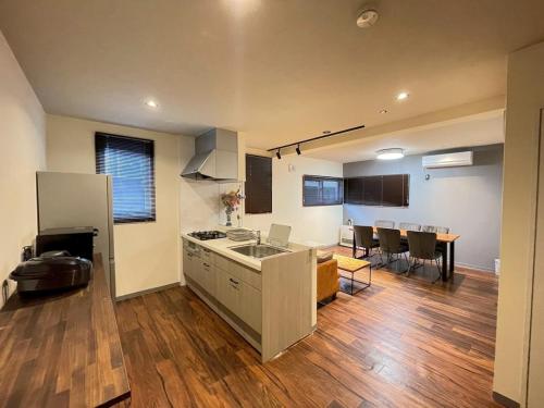 een keuken met een wastafel en een tafel in een kamer bij KUSUO HOUSE Roji in Sapporo