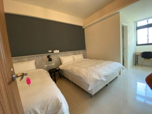 a hotel room with two beds and a window at Yun Tian Homestay in Jincheng