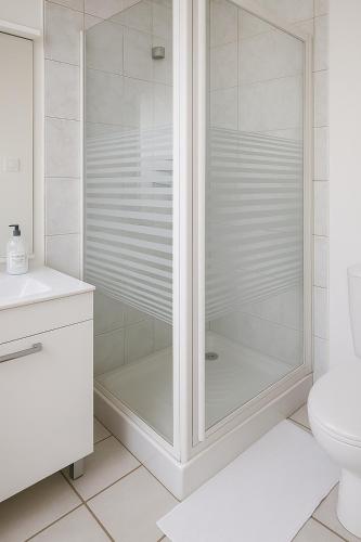 une douche avec une porte en verre dans une salle de bain dans l'établissement Studio cosy à 5 min de la mer, à Antibes