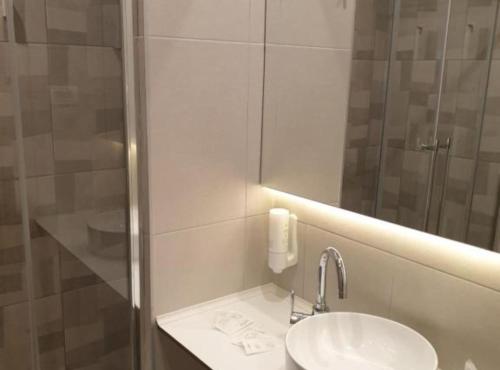 Gateway to Herzegovina’s Heritage في Vrgorac: حمام أبيض مع حوض ومرآة