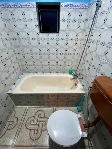 a bathroom with a toilet and a bath tub at Amelie Apartments and Stay Inn in Pokhara