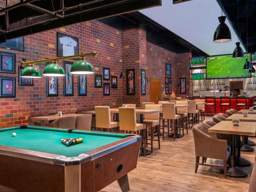 a pool table in a restaurant with tables and chairs at Ibis Styles Dragon Mart Dubai in Dubai