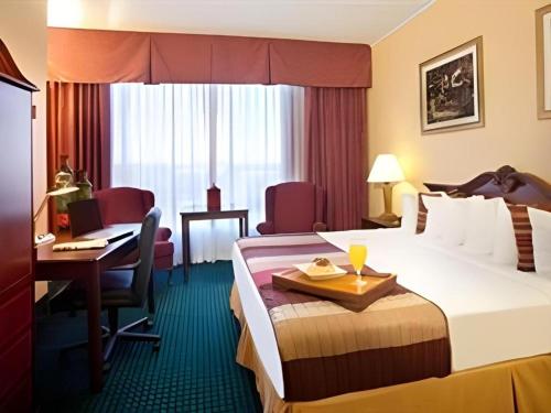 Postel nebo postele na pokoji v ubytování Magnuson Grand Conference Hotel