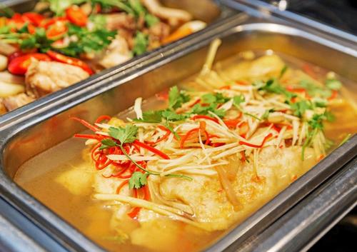 ein Metallbehälter gefüllt mit Suppe mit Käse und Gemüse in der Unterkunft Siren Flower Hotel in Nha Trang