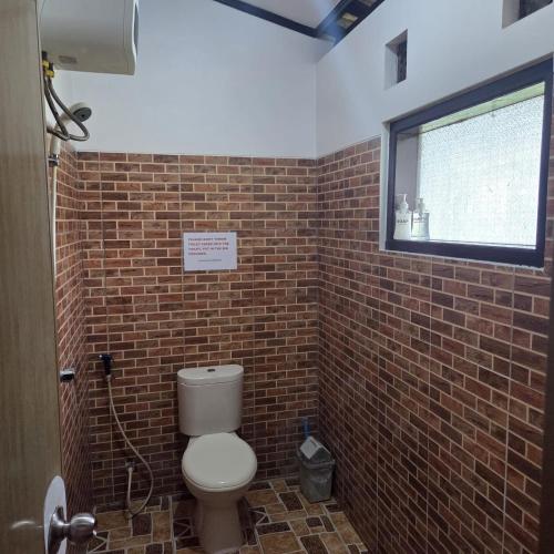 un bagno con un water e un muro di mattoni di Java Lagoon a Pangandaran