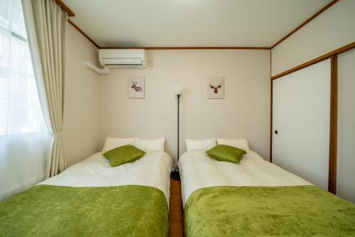 two beds sitting next to each other in a room at Casa G,S, - Vacation STAY 93709v in Osaka