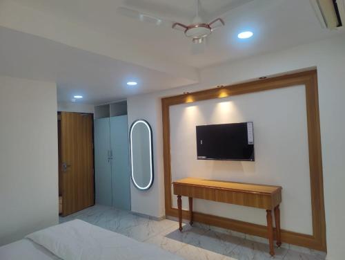 een kamer met een bureau en een televisie aan de muur bij Januson Hotel in Koba