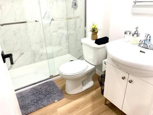 a bathroom with a shower and a toilet and a sink at Royal Oak in Winnipeg
