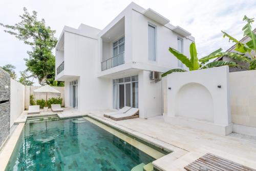 a white house with a swimming pool in front of it at Villa Buho Ungasan - Luxury Villa 4br in Ungasan