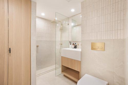 a bathroom with a shower and a toilet and a sink at Noosa Harbour Resort in Noosa Heads
