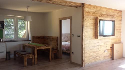 Zimmer mit einem Tisch und einem Zimmer mit einem Bett in der Unterkunft Apartmány Benecko 155 in Benecko