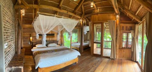 a bedroom with a bed in a room with wooden floors at Pu Luong Ecostay in Lũng Tiềm