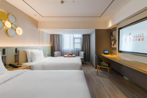 Giường trong phòng chung tại Orange Hotel Shenzhen Futian Convention and Exhibition Center