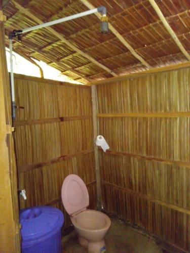 a small bathroom with a toilet and a blue bucket at " Wobbegong Raja Ampat " in Yennanas Besir
