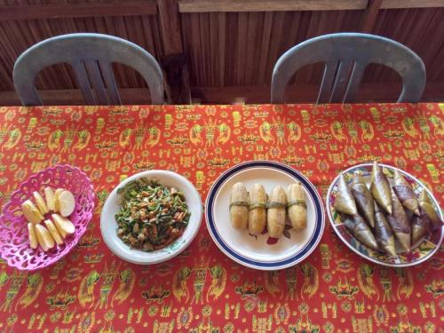 Una mesa roja con platos de comida encima. en " Wobbegong Raja Ampat ", en Yennanas Besir
