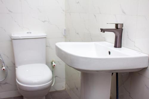 Un baño con lavabo blanco y inodoro. en De Groove Apartment, en Addo
