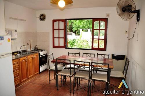 una cucina con tavolo, sedie e finestra di Complejo Zara a Villa Carlos Paz