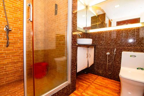 a bathroom with a shower and a toilet at Mia Riaan Lake View Resort in Ernakulam