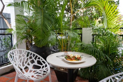 a white table with a plate of food on a patio at Samaya Boutique & Cuisine in Phnom Penh