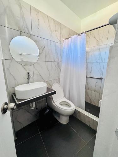 MancosLos Angeles Alojamiento的浴室里有马桶、洗手池和淋浴。