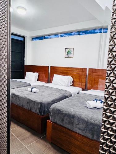 MancosLos Angeles Alojamiento的一间有两张床和一扇窗户的酒店房间