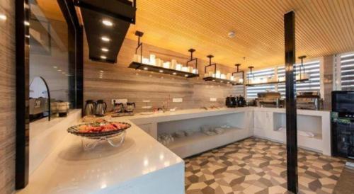a kitchen with a bowl of fruit on a counter at Echarm Hotel Fuzhou Sanfang Qixiang East Street Metro Station in Fuzhou