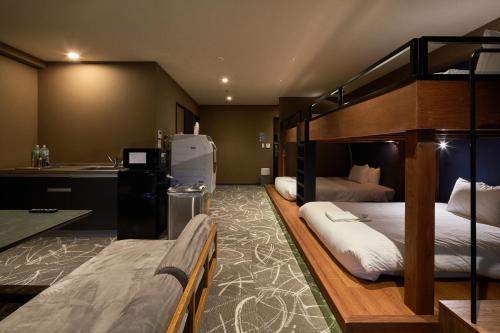 two bunk beds in a room with a kitchen at B/C HOTEL NAHA Hotel with Rental Car in Naha