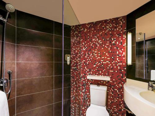 a bathroom with a toilet and a shower and a sink at ibis Hyderabad Hitec City - An Accor Brand in Hyderabad