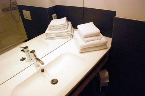 a bathroom with a sink with towels on it at Altstadthotel Bauern Bräu Schrobenhausen in Schrobenhausen