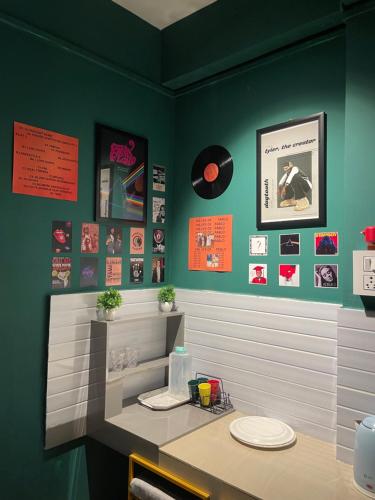 River View Homestay في ديبروجاره: غرفة طعام بجدران خضراء وطاولة