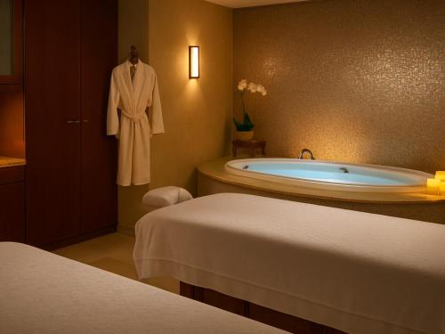 a bathroom with a tub and a robe on a wall at The Westin Kāʻanapali Ocean Resort Villas- Island View STUDIO VILLA in Lahaina