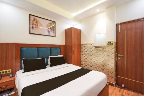 Super Townhouse Kali Ghat Prayagraj Formerly Ramesh Palace في Prayagraj: غرفة نوم مع سرير كبير وخزانة