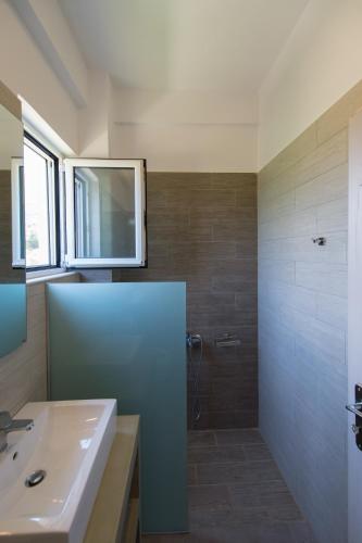a bathroom with a sink and a shower at Thesmos Village in Mýtikas