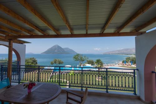 a balcony with a table and a view of the ocean at Thesmos Village in Mýtikas