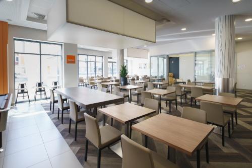Un restaurante con mesas, sillas y ventanas. en Holiday Inn Express Strasbourg Centre by IHG, en Estrasburgo