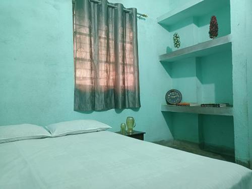 a bedroom with a bed and a window with a clock at santosh lodge in Muzaffarpur