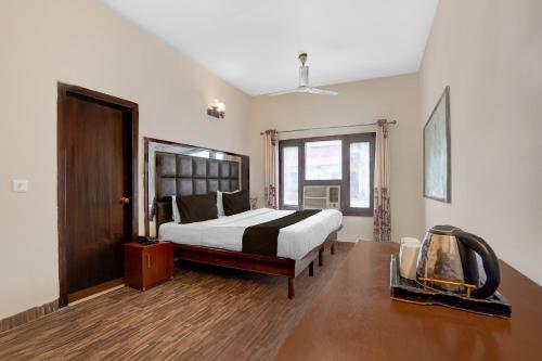 a large bedroom with a bed and a window at Hotel O Ashtley Hall Dehradun Formerly Daichi in Dehradun