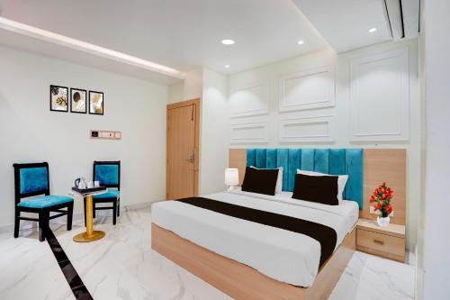 a bedroom with a bed and a desk and a chair at Super Townhouse Oak Prayagraj Allahabad University - Railway Junction Formerly Ballians in Prayagraj