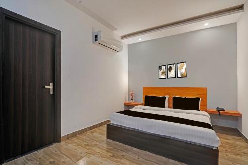 a bedroom with a large bed and a black door at Super Townhouse Sector 9 Gurgaon in Gurgaon