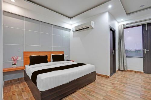 a bedroom with a large bed and a window at Super Townhouse Sector 9 Gurgaon in Gurgaon