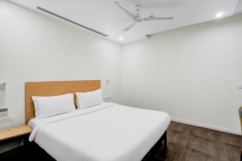 a bedroom with a white bed and a ceiling fan at Hotel Heaven Luxes Opp Miraj Cinemas in Hyderabad