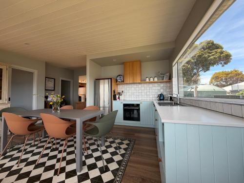 an open kitchen and dining room with a table and chairs at Beach Buoy Opossum Bay in South Arm