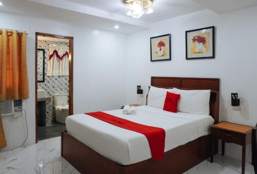 une chambre avec un grand lit blanc avec des oreillers rouges dans l'établissement RedDoorz at La Casa Guesthouse former RedDoorz at Tamarind Street Angeles City, à Ángeles