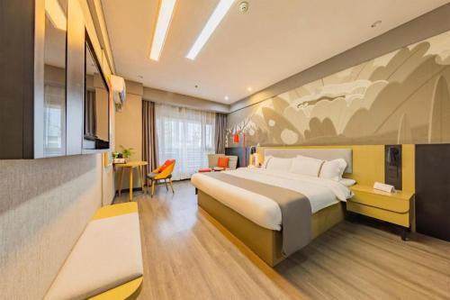 Thank Inn Hotel Hubei Wuhan Caidian Zhong Fa Xincheng Tongji في ووهان: غرفة فندقية بها سرير كبير ومكتب