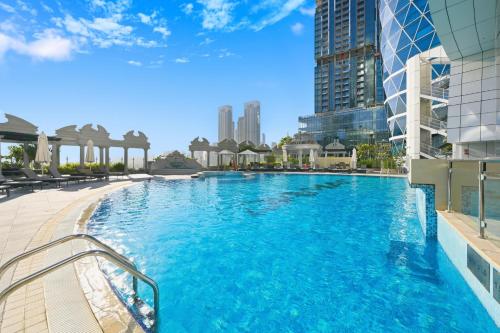 a large swimming pool in a city with buildings at Difc 1 Bd apartment in Park Tower in Dubai
